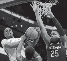  ?? JIM WEBER/DAILY MEMPHIAN VIA AP ?? Memphis guard Alex Lomax, left, is fouled by UConn’s Akok Akok while shooting under pressure by Josh Carlton (25) during a game Feb. 1 at the FedExForum in Memphis.