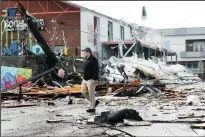  ?? TRIBUNE NEWS SERVICE ?? A man walks through downtown Nashville on Tuesday after a deadly tornado ripped through town.