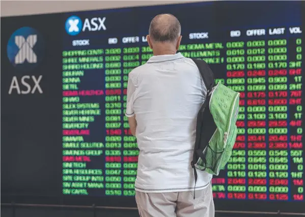  ?? Picture: BROOK MITCHELL/GETTY IMAGES ?? NUMBER CRUNCH: A man watches the stock market yesterday as the Reserve Bank cuts the cash rate to a record low 0.5 per cent.