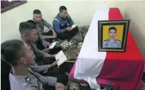  ?? Tatan Syuflana / AP Photo ?? Police officers pray over the coffin of a colleague who was killed in Wednesday’s suicide bombings.