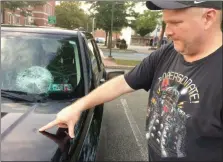  ?? EVAN BRANDT — MEDIANEWS GROUP ?? Pottstown Borough Councilman Don Lebedysnky points to a dent on the hood of his vehicle in addition to his smashed windshield.