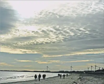  ?? PICTURE: TONY JOHNSON ?? WINTRY OUTLOOK: Walkers enjoy the mild weather at Bridlingto­n’s south beach – but change is on the way.