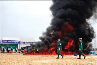  ?? HENG CHIVOAN ?? NACD officials destroy drugs in Phnom Penh’s Meanchey district in July.