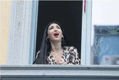  ?? LUCA BRUNO THE ASSOCIATED PRESS FILE PHOTO ?? Opera singer Laura Baldassari joins a balcony flash mob created in Italy on March 13 to help people weather the lockdown.