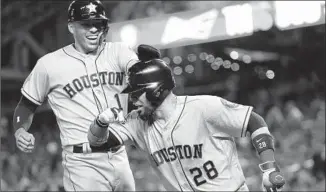  ?? Patrick Smith Getty Images ?? HOUSTON’S Robinson Chirinos (28) hit his second home run in as many days against the Nationals, a two-run shot in the fourth inning, drawing congratula­tions from Carlos Correa.