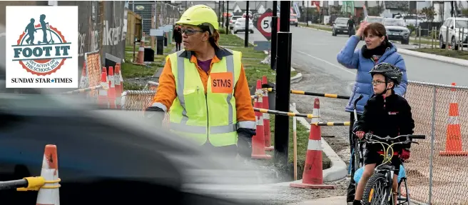  ?? IAIN MCGREGOR / FAIRFAX NZ ?? Tuari Manuel, 7, and mum Courtney Manuel cross the road with the help of Deborah Cooney, traffic manager for City Care at Prestons Rd in Christchur­ch.