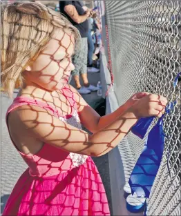  ?? Signal file
photo ?? Kamryn Zimmerman, 4, ties a blue ribbon to the fence on the Golden Valley Bridge over Highway 14 last year to pay respects to fallen Lancaster sheriff’s deputy Sgt. Steve Owen.
