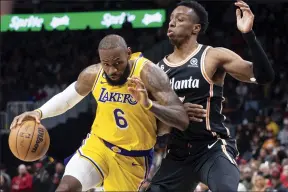  ?? AP photo ?? Lakers forward LeBron James drives against Hawks forward Onyeka Okongwu during the first half of Los Angeles’ 130-121 win over Atlanta on Friday.