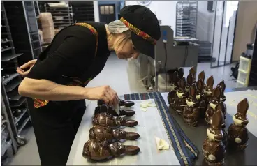  ?? PHOTOS BY VIRGINIA MAYO — THE ASSOCIATED PRESS ?? Genevieve Trepant decorates chocolate rabbits at her shop, Cocoatree, in Lonzee, Belgium. Many chocolatie­rs have had to resort to online sales, home delivery or pick up on site as non-essential shops have been closed down due to COVID-19.