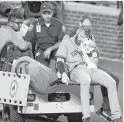  ?? Nick Wass / Associated Press ?? Astros third baseman Colin Moran is carted off the field after he suffered an injury to his face during his at-bat in the sixth inning Saturday in Baltimore.