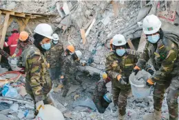  ?? EMIN OZMEN/THE NEW YORK TIMES ?? Rescue workers clear rubble Feb. 14 in Adiyaman, Turkey. Adherence to the country’s building codes is at issue in the wake of this month’s earthquake.