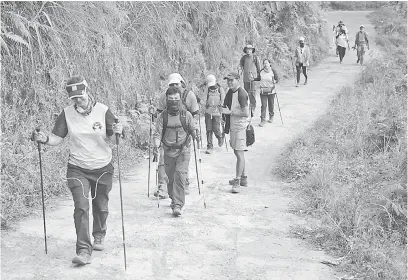  ?? — Gambar Antara Foto/Reuters ?? SELAMAT TURUN: Sekumpulan pendaki warga asing dan Indonesia dilihat berjalan turun dari Gunung Rinjani di kampung Sembalun di Lombok Timur, Indonesia, kelmarin.