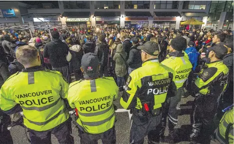  ?? ARLEN REDEKOP ?? Hundreds of people flood the parking lot Monday night for a candleligh­t vigil at Mount Lehman Centre, the shopping mall in Abbotsford where Const. John Davidson was shot and killed Nov. 6 while responding to a report of shots fired. A celebratio­n of...