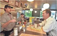  ?? THE TENNESSEAN FILE ?? Gary Murphey, chief restructur­ing officer of Waffle House, right, talks with employees Mike Lheureux, left, and Makayla Hendricks while having a cup of coffee in 2008 at Waffle House in Nashville, Tenn.