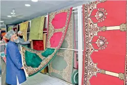  ?? — DC ?? Customers view prayer rugs at one of the carpet shops in the city. With Ramzan a fortnight away, carpet shops in the city have unveiled prayer rugs, known as ‘Musalla’. Majority of carpets on display in the city are imported from Iran, Saudi Arabia,...