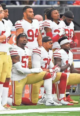  ??  ?? The 49ers’ Eli Harold (57), Eric Reid (35) and wide receiver Marquise Goodwin (11) kneel for the national anthem. SHANNA LOCKWOOD/USA TODAY SPORTS