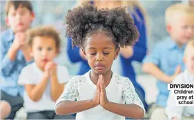  ??  ?? DIVISION Children pray at school