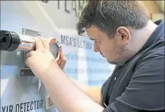  ?? Pam Panchak/Post-Gazette ?? Jesse Regalski, a senior at Nazareth Prep in Emsworth, checks out an Altair Single-Gas Detector made by MSA Safety at the company’s campus in Cranberry.