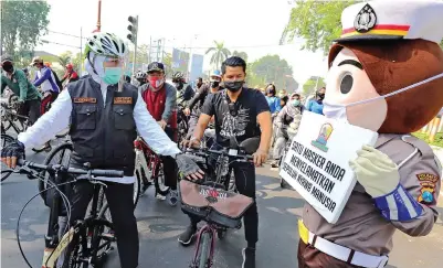  ?? DITE S/JAWA POS ?? AJAK DISIPLIN: Gubernur Jawa Timur Khofifah Indar Parawansa bersepeda bersama Ikatan Alumni Penyintas Covid-19 Jawa Timur di Sidoarjo kemarin. Khofifah juga membagikan masker kepada warga.