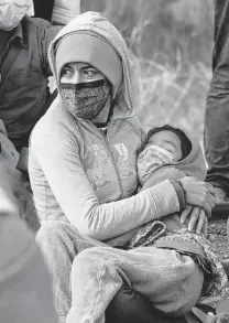  ?? Jerry Lara / Staff photograph­er ?? A mother and child in a group of migrants, most from Central America, are detained by Border Patrol agents near La Joya.