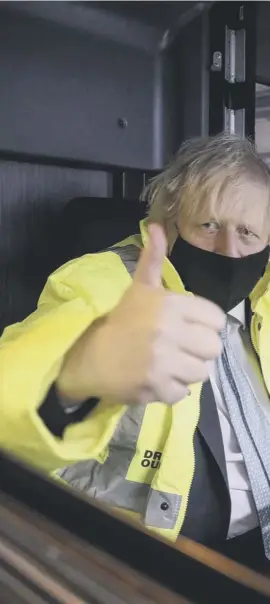  ??  ?? 0 Boris Johnson on a bus alongside electric vehicles operations manager Agata Litwinowic­z-soltysiak, during a visit to the National Express depot in Coventry