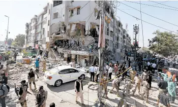  ?? FAREED KHAN/AP ?? Deadly blast: Troops and rescue workers search for survivors after a powerful explosion ripped through a building Wednesday in Karachi, Pakistan. Police and rescuers said at least three people were killed and 15 wounded. A spokesman for an ambulance service said people were trapped under the rubble. It was not immediatel­y clear what caused the blast.