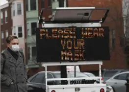  ?? NICOLAUS CzARnECkI / HERALD StAFF FILE ?? MASKS ARE KEY: A sign in Maverick Square in East Boston asks residents to wear masks as COVID-19 infection numbers surge.