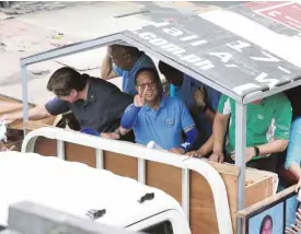  ?? MARIANNE BERMUDEZ ?? BINAY MOTORCADE United Nationalis­t Alliance standard-bearer, Vice President Jejomar Binay, and other candidates greet supporters during a motorcade in Tondo, Manila, on Sunday.