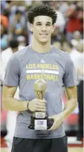  ?? — AP ?? LAS VEGAS: Los Angeles Lakers’ Lonzo Ball holds up the trophy for the most valuable player in the NBA summer league, before the team’s basketball game against the Portland Trail Blazers in Las Vegas.