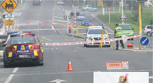  ?? PHOTO: HAMISH MACLEAN ?? Scene examinatio­n . . . Oamaru police and the serious crash unit yesterday investigat­e the scene of an alleged hitandrun incident in which a 14yearold Oamaru schoolgirl was killed on Tuesday night. Right: Flowers at the scene.