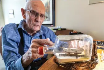  ?? CITIZEN PHOTO BY CHUCK NISBETT ?? Rae McIntyre, 88, describes how he tackled the first ship in a bottle he did in 1993.