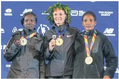  ??  ?? Shalane Flanagan, centre, poses for a photo with Mary Keitany, right, and Mamitu Daska.