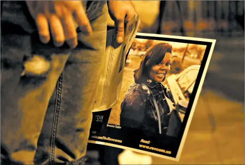  ?? JOHN J. KIM/CHICAGO TRIBUNE ?? A man holds a poster with a photograph of Breonna Taylor during a rally to remember Taylor last week in Chicago. Taylor was fatally shot by Louisville police in March.