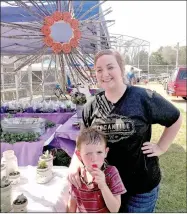  ??  ?? Haley Harris gets some help from her son, Casen, marketing and selling her autumn crafts at the Ozark Orchard Festival. Harris, from Neosho, said this was her first venture in selling her crafts, perfect for decorating for the fall.