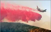  ??  ?? A fixed-wing tanker makes a drop of fire retardant on a 25-acre fire on Bouquet Canyon Road near Spunky Canyon Road on Thursday.