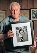  ?? PATRICK RAYCRAFT / GETTY IMAGES ?? George Mendonsa holds the iconic photo at his home in Rhode Island in 2012.