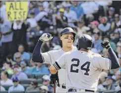  ?? Ted S. Warren / Associated Press ?? A fan holds a sign that reads “All Rise” as the Yankees’ Aaron Judge, left, greets Gary Sanchez (24) after Judge hit a two-run home run against the Seattle Mariners during the fifth inning of Wednesday night’s game in Seattle.