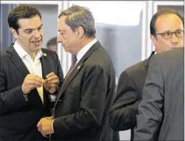  ?? MICHEL EULER / ASSOCIATED PRESS ?? Greek Prime Minister Alexis Tsipras (left) talks to European Central Bank President Mario Draghi during a roundtable meeting at an emergency eurozone summit Tuesday in Brussels. Tsipras and Finance Minister Euclid Tsakalotos arrived at the meeting...