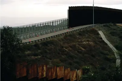  ?? The Associated Press ?? Q An incomplete secondary wall stands alongside the previous version near where the border separating Tijuana, Mexico, and San Diego meets the Pacific Ocean on Tuesday in Tijuana.