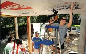  ?? NWA Democrat-Gazette/ANDY SHUPE ?? Volunteer Maggie Benson (right) of Fayettevil­le uses a nail gun Saturday to install a moisture barrier on the ceiling of a porch while working at a home being built by Habitat for Humanity of Washington County in Fayettevil­le. Graduates from the...