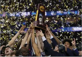  ?? DAVID J. PHILLIP — THE ASSOCIATED PRESS ?? Connecticu­t celebrates with the trophy after their win against San Diego State during the men’s national championsh­ip on Monday in Houston.