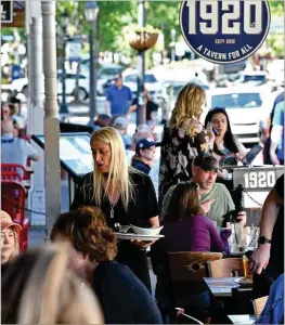  ?? HYOSUB SHIN/HYOSUB.SHIN@AJC.COM 2021 ?? Jenna Aronowitz (center) serves customers at 1920 Tavern restaurant. The mayor has wanted to close Canton Street to traffic from Ga. 9/Magnolia Street to East Alley including Elizabeth Way on summer weekends.