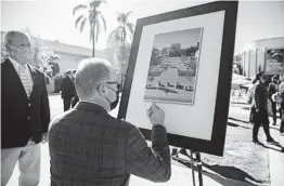  ?? ARIANA DREHSLER ?? Mayor Kevin Faulconer signs a photo of the new Palisades Plaza at its opening.