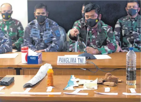  ?? FOTO: FIRDIA LISNAWATI/DPA ?? Der indonesisc­he Militärche­f Hadi Tjahjanto (Zweiter von rechts) spricht mit den Medien, während Trümmertei­le auf einem Tisch liegen, die während einer Suchaktion nach dem U-Boot „KRI Nanggala 402“der indonesisc­hen Marine gefunden wurden.