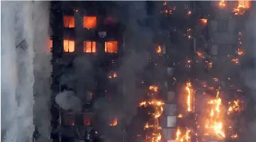  ??  ?? File photo shows flames and smoke billowing as firefighte­rs deal with a serious fire in a tower block at Latimer Road in West London. — Reuters photo