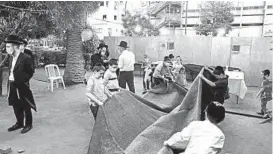  ?? AMIR LEVY/GETTY ?? Ultra-Orthodox Jews build an outdoor synagogue Thursday in Bnei Brak, Israel, ahead of a three-week coronaviru­s lockdown. The second nationwide lockdown begins Friday.