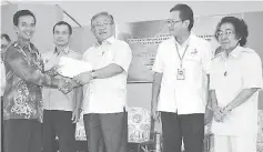  ??  ?? Sikie (centre) hands over an appointmen­t letter to one of the longhouse chiefs while Nyurak (fourth right) and others look on.