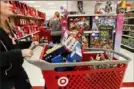  ?? John Minchillo/AP ?? Shoppers browse the aisles during a Black Friday sale at a Target store in Newport, Ky., in 2018.