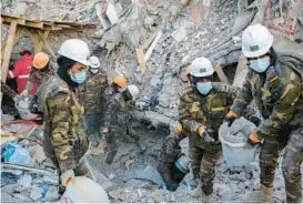  ?? EMIN OZMEN/THE NEW YORK TIMES ?? Rescue workers clear rubble Feb. 14 in Adiyaman, Turkey. Adherence to the country’s building codes is at issue in the wake of this month’s earthquake.