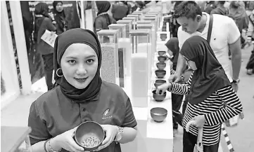  ??  ?? Norazuwa Mat Rahim showing the bario fragrant yam rice from Sabah at Maha 2018. - Bernama photo